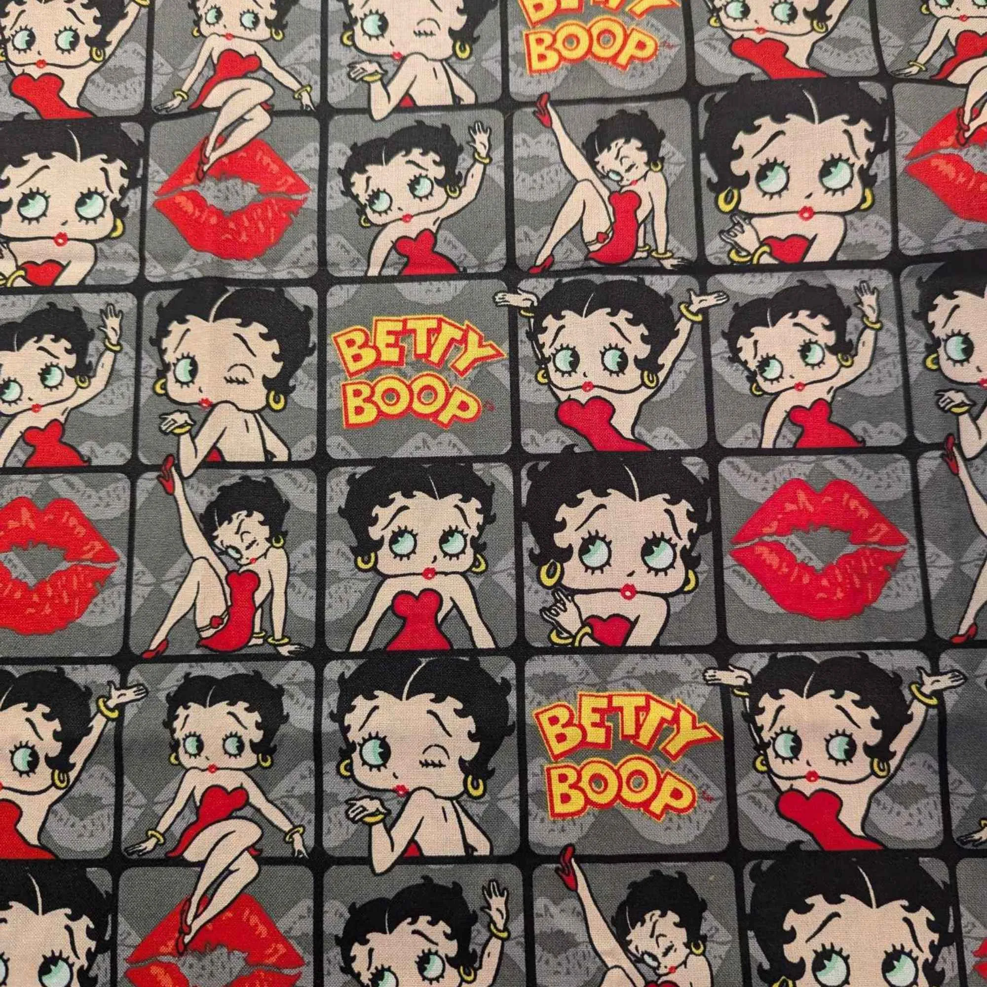 Betty Boop poses in 2" frames on grey fabric